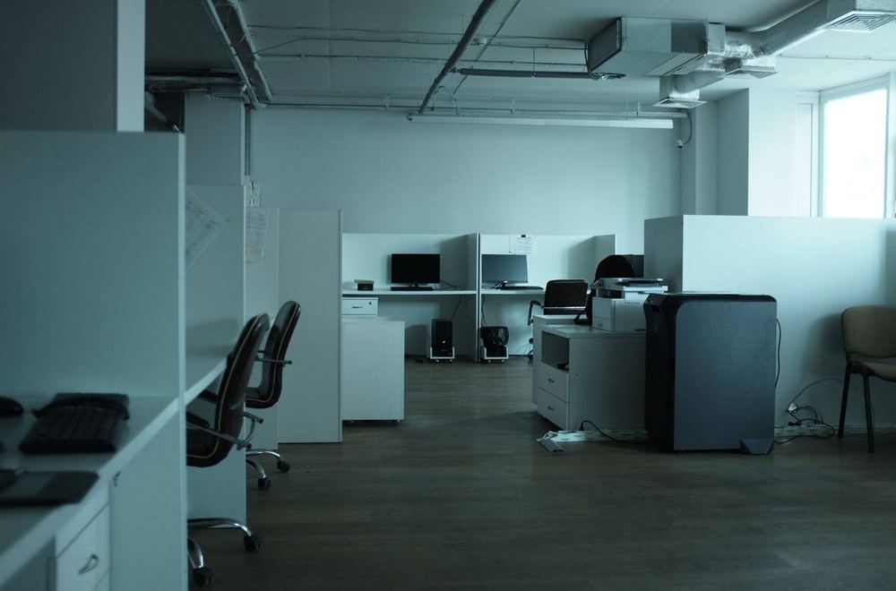 Empty open office with desks, chairs, and computers.