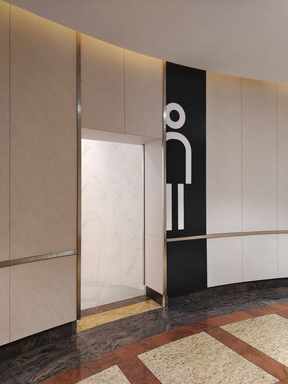 Entrance to a commercial restroom with stone flooring.